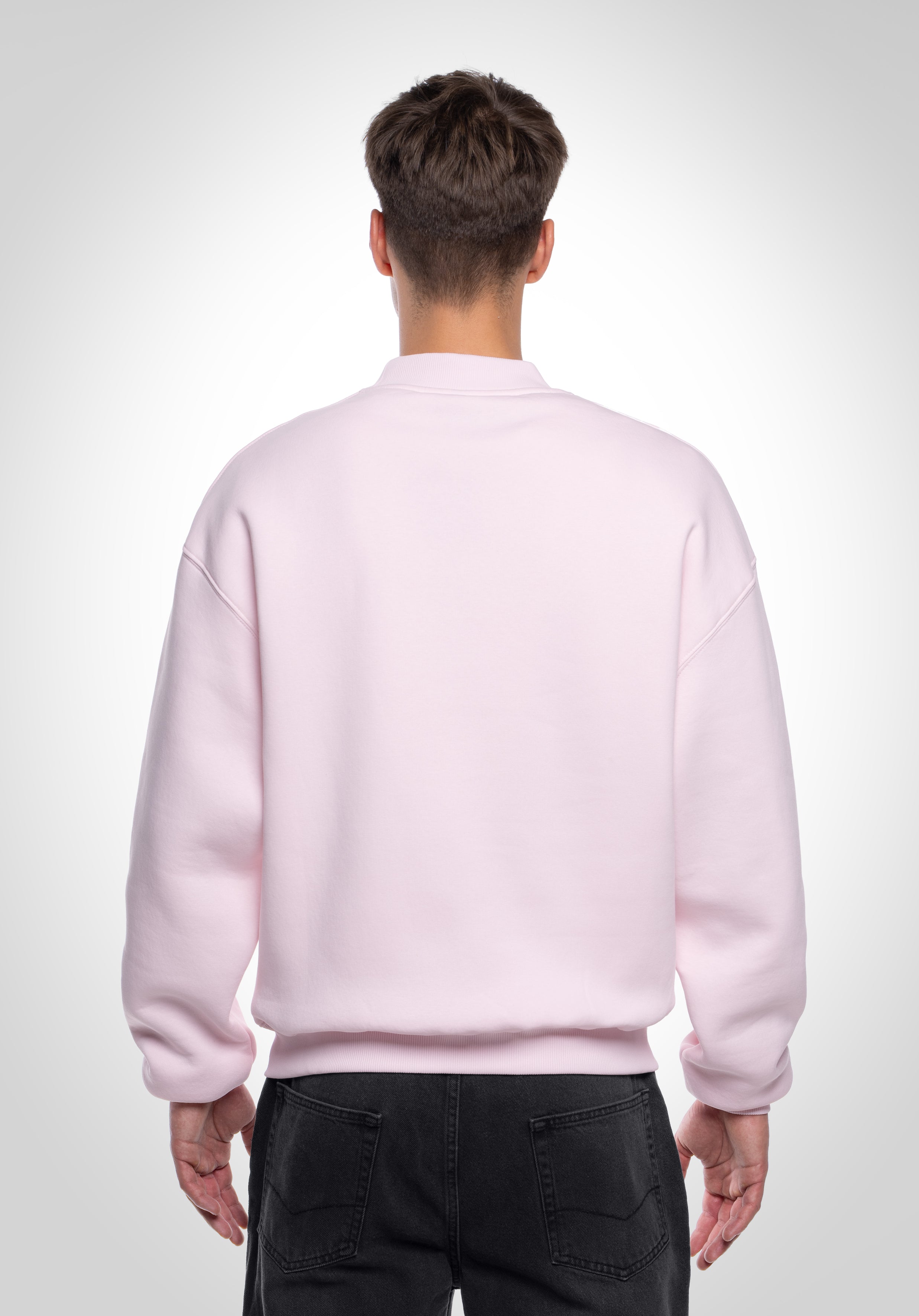Rückenansicht eines hellrosa Oversized-Sweatshirts für Herren, zeigt den lockeren Schnitt und die saubere Verarbeitung.
