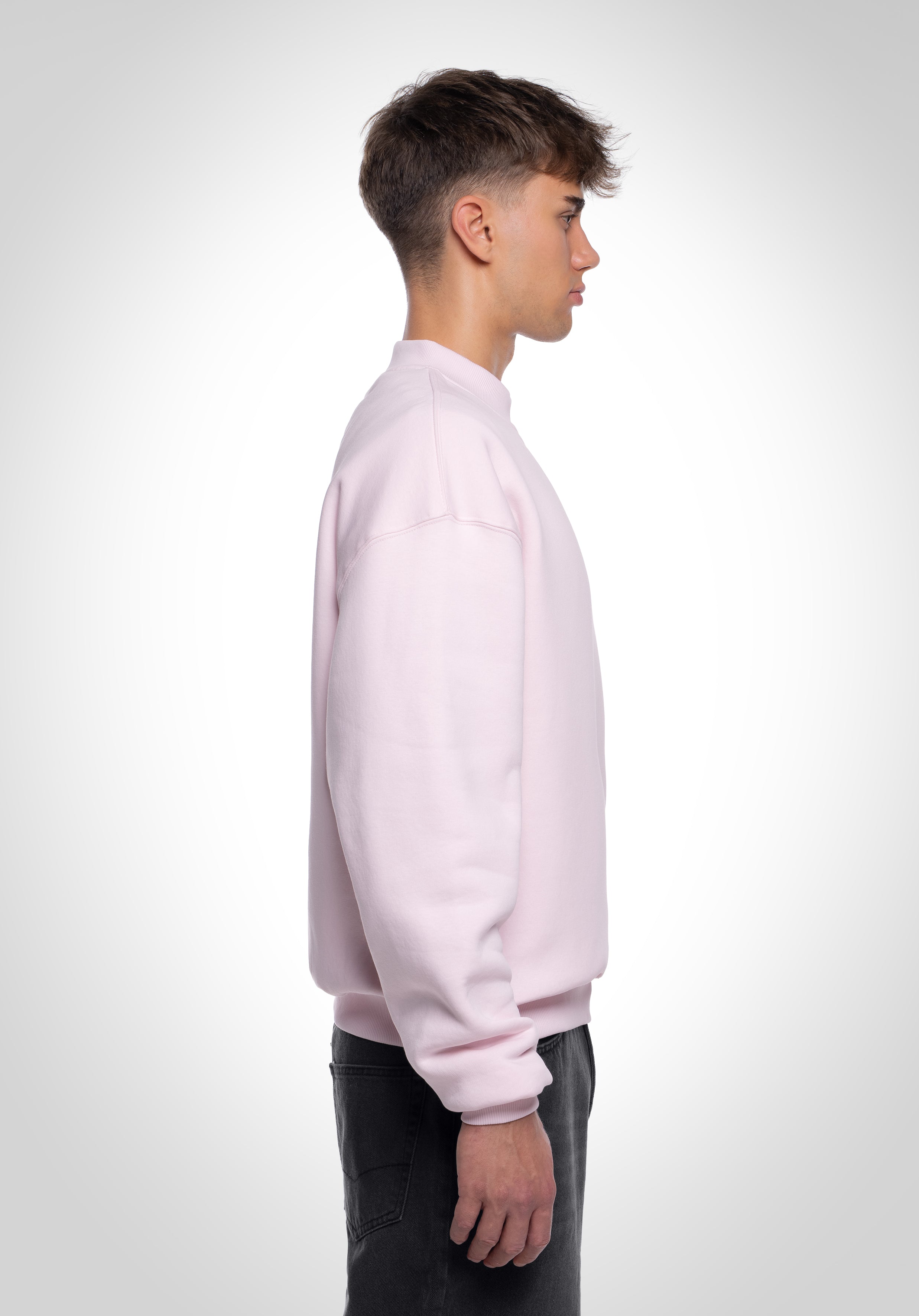 Seitenansicht eines hellrosa Oversized-Sweatshirts für Herren, minimalistisch und bequem geschnitten
