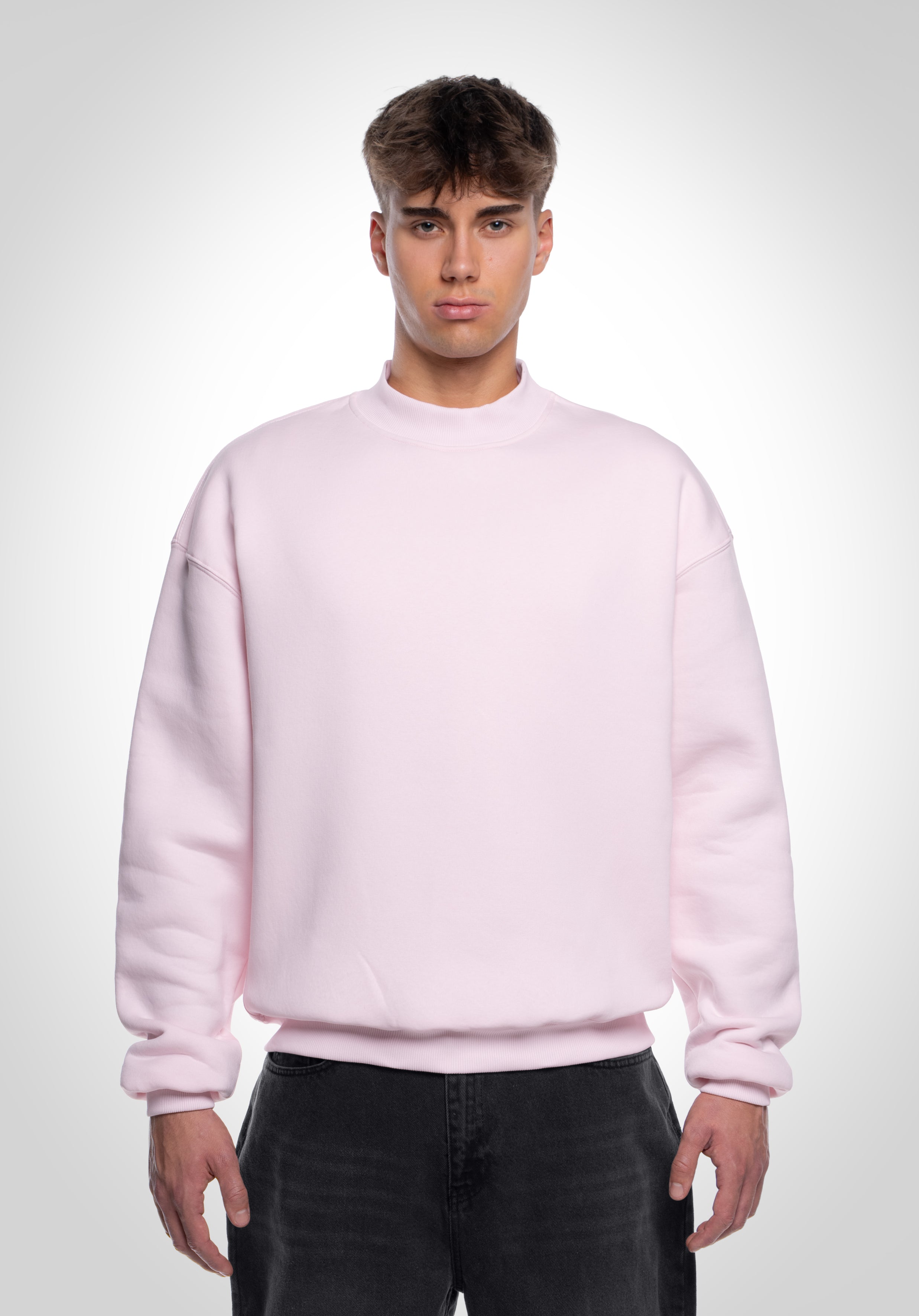 Vorderansicht eines hellrosa Oversized-Sweatshirts Unisex, schlichtes Design mit lockerem Sitz und weichem Stoff.