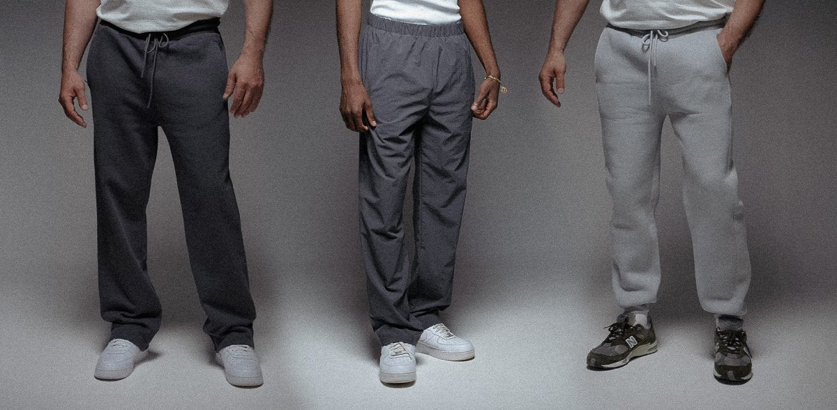 Drei Personen tragen unterschiedliche Jogginghosen in Dunkelgrau, Grau und Hellgrau, kombiniert mit weißen Sneakers. Die Hosen haben lockere Schnitte und sind für Alltag und Freizeit geeignet.