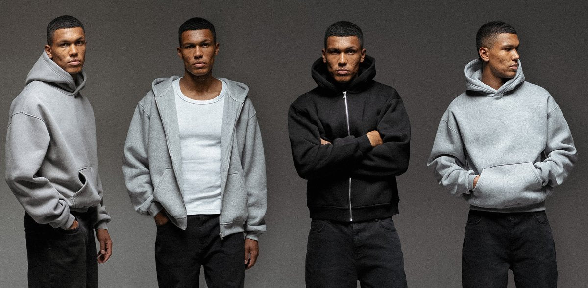 Vier Männer tragen verschiedene Oversized Hoodies von Straight Outta Cotton in gedeckten Farben – Kategorie-Banner für Hoodies