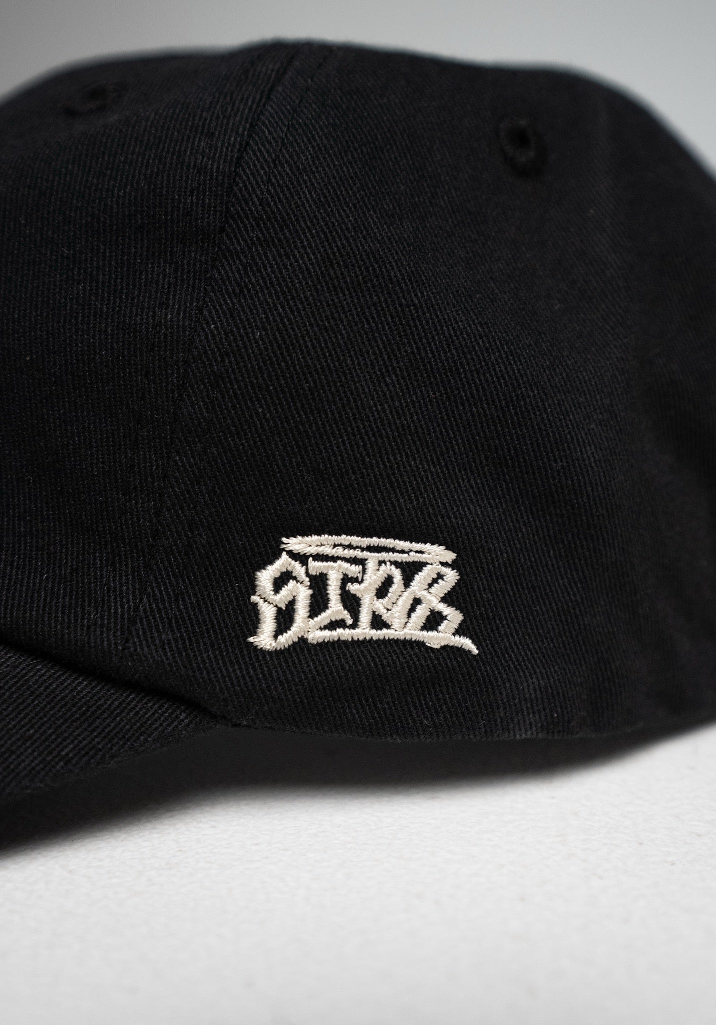 6 Panel Cap „Str8" in Black – Detailansicht der seitlichen Stickerei „Straight – Str8"